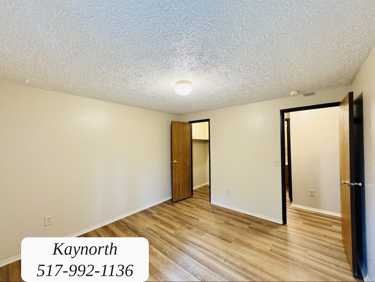 Bedroom with closet doors and wood-look floors in a Kaynorth apartment