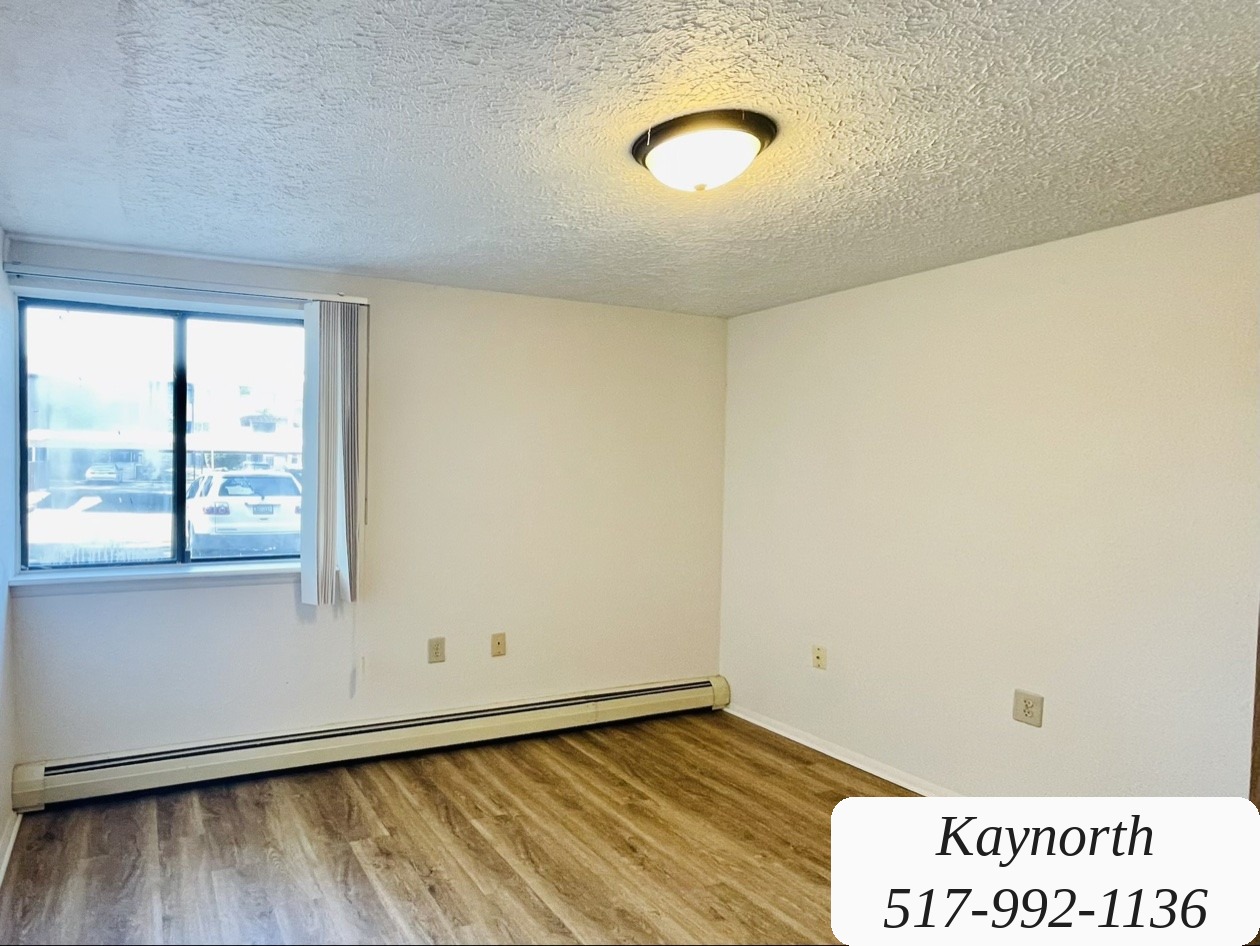 Sunlit bedroom in a Kaynorth two-bedroom apartment, with wood-look floors