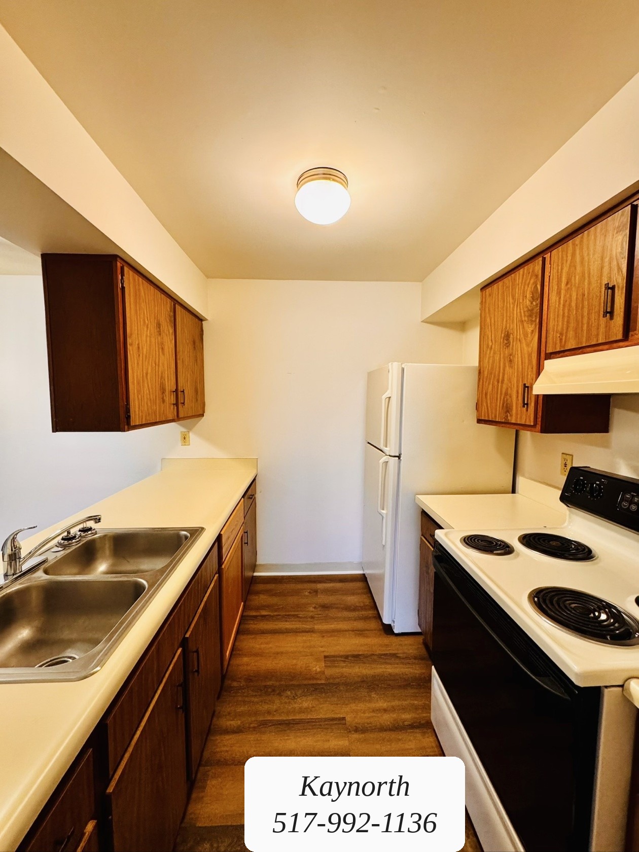 Kitchen with dark wood cabinets and a double sink in a Kaynorth apartment