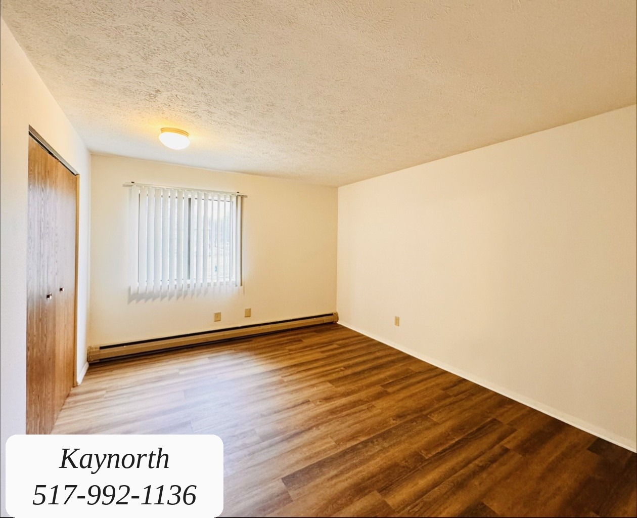 Bedroom with closet doors and a window in a Kaynorth apartment