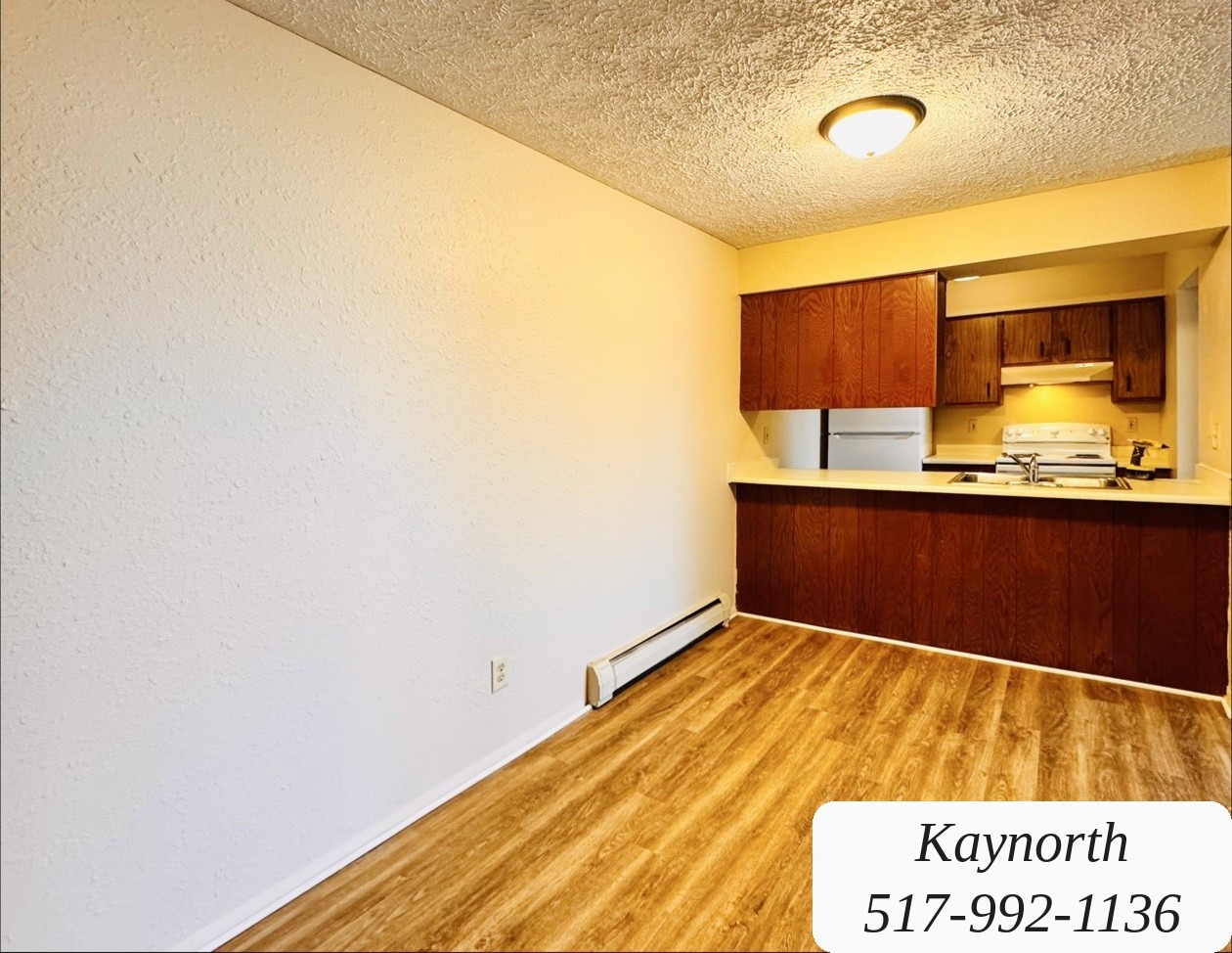 Living room opening into the kitchen past a breakfast bar in a Kaynorth apartment
