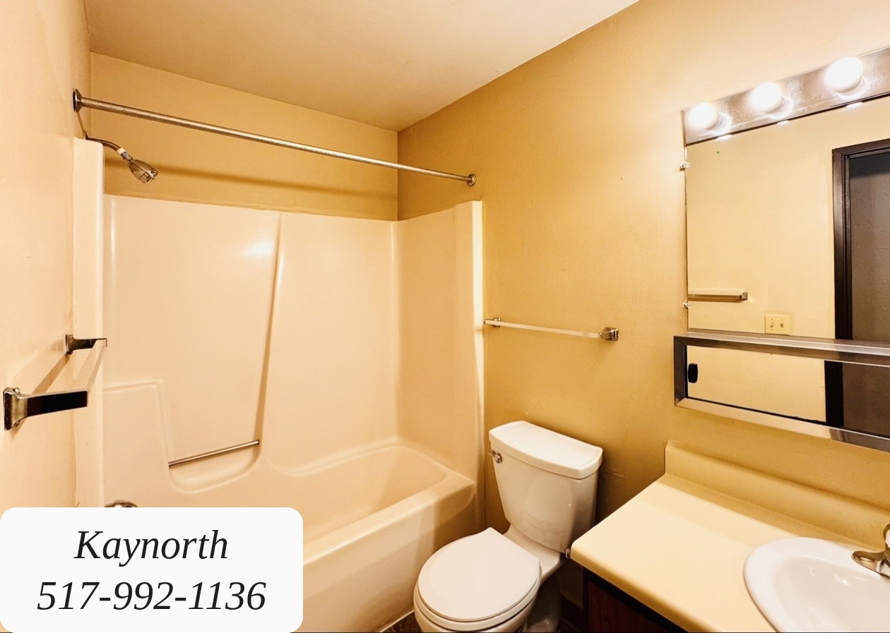 Bathroom with tub and shower, toilet, and vanity in a Kaynorth apartment
