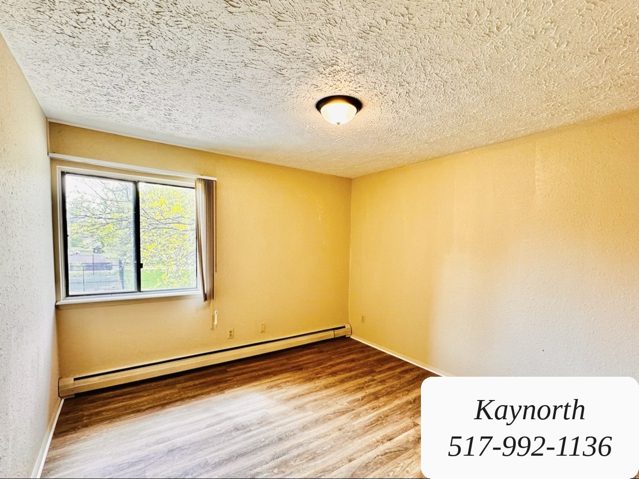 Bedroom with a window and wood-look floors in a Kaynorth apartment