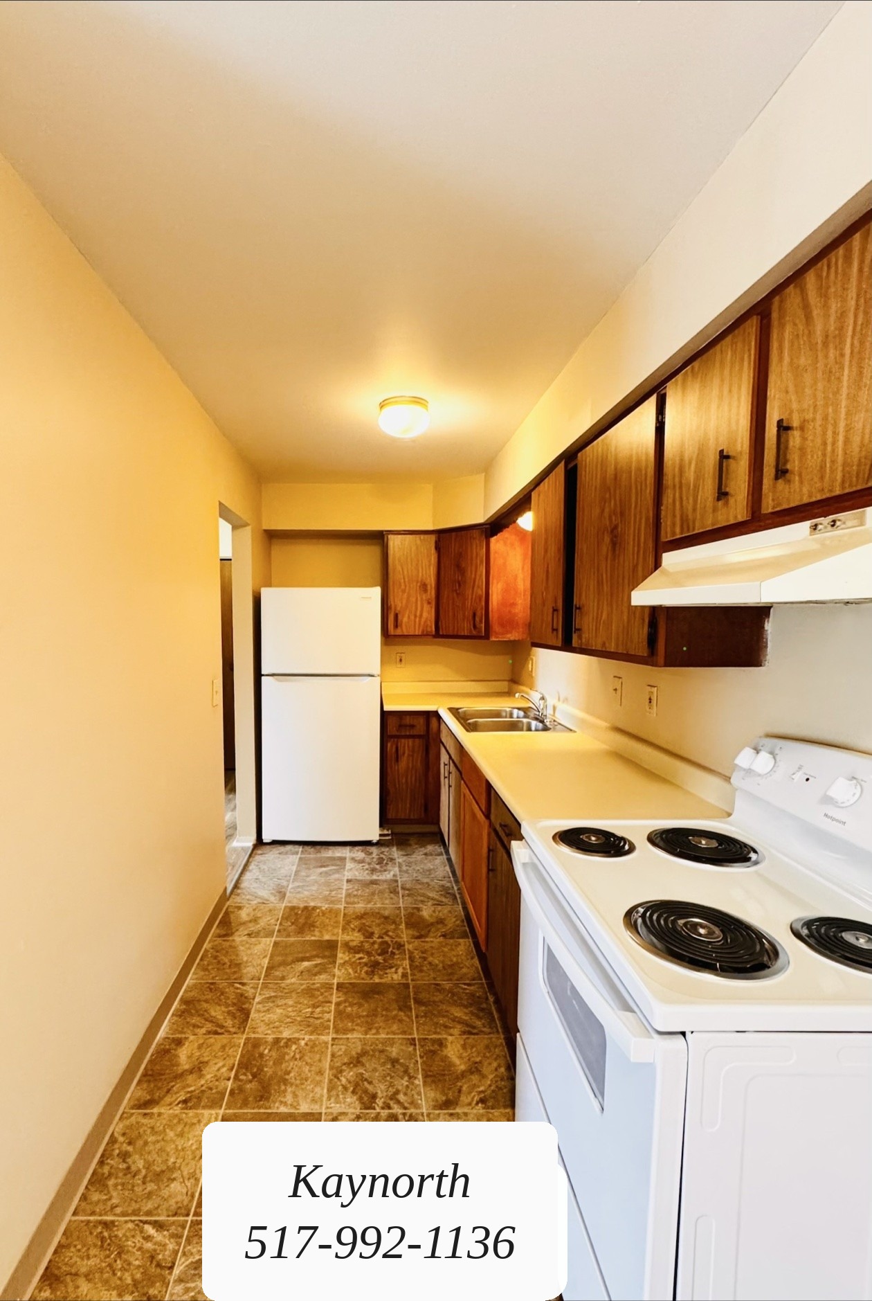 Kitchen with dark wood cabinets and a tile floor in a Kaynorth apartment