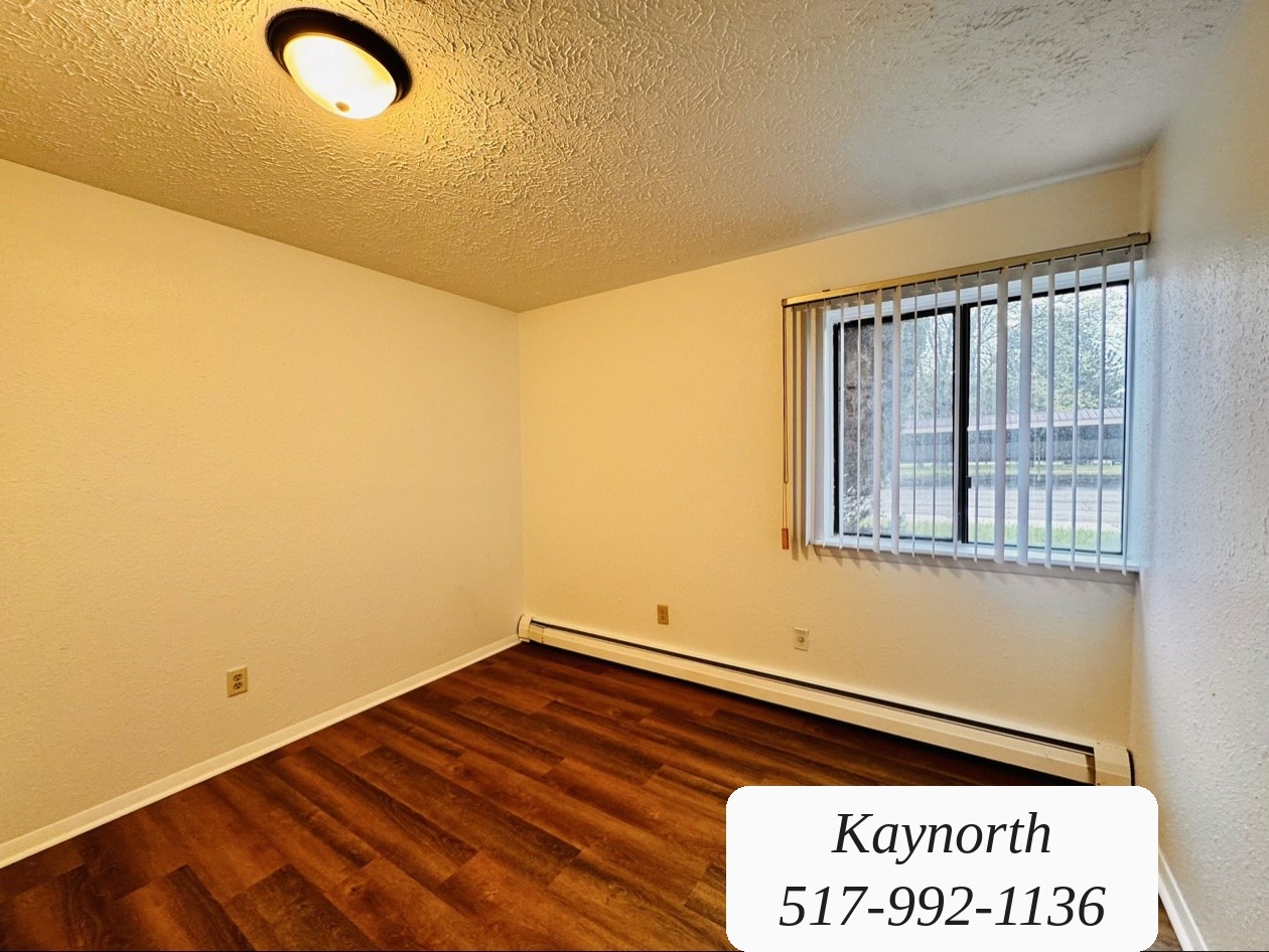 Bedroom with window blinds and wood-look floors in a Kaynorth apartment